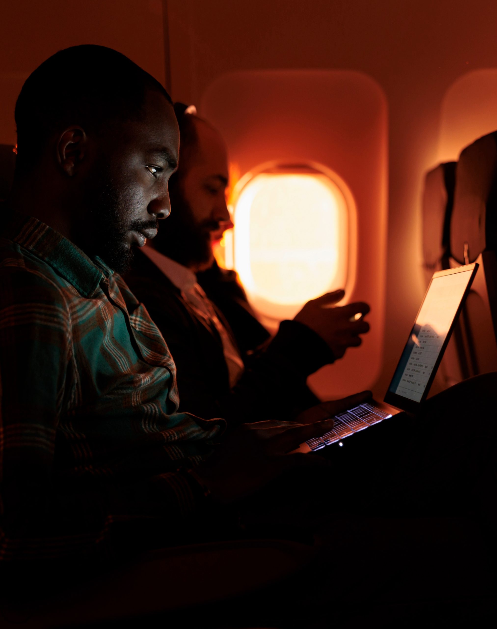 freelancer-passenger-working-laptop-sunset-flying-by-airplane-commercial-flight-with-international-airline-service-male-tourist-travelling-work-trip-holiday (2) (1)